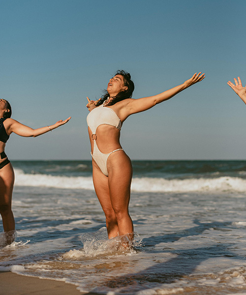 Mujeres celebrando en el mar durante una formación de Love Flow Yoga